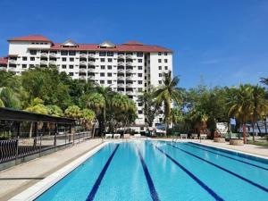 a large swimming pool in front of a hotel at GloryBeachResort2BedroomWifiNetflixFreeparking in Port Dickson