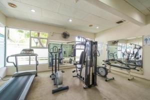 a gym with treadmills and machines in a room at GloryBeachResort2BedroomWifiNetflixFreeparking in Port Dickson