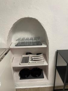 ソフィアにあるSocial Guest Houseの壁に棚があり、皿やグラスがいくつか置かれている