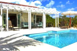 a patio with a swimming pool and a pergola at Esencia Cottage in Providenciales +55 photos
