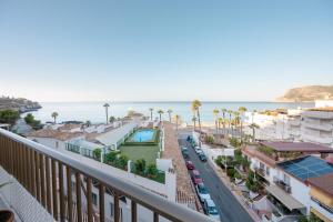 Una vista del océano desde el balcón de un edificio. en Rincón de la Caleta, en La Herradura