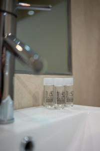 Tres vasos sobre el mostrador del baño frente a un lavabo. en Rincón de la Caleta, en La Herradura 24 fotos más