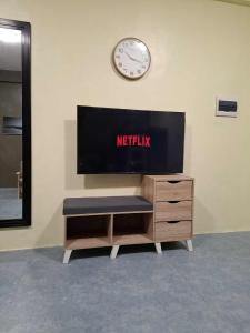 Un televisor en una pared con un reloj encima. en The Baluarte, en Maasin