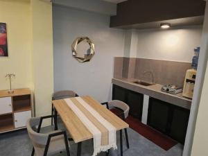 Una cocina con una mesa y sillas y un fregadero. en The Baluarte, en Maasin