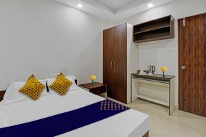 a bedroom with a bed with yellow and blue pillows at Hotel O Zois Nest in Kammasandra