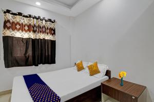 a white room with a bed and a window at Hotel O Zois Nest in Kammasandra