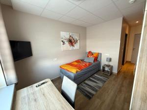 a room with a couch and a tv in it at Pension in Laatzen bei Hannover in Hannover