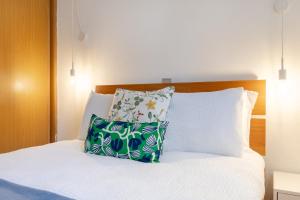 a bedroom with a bed with two pillows at Casa Paulinha in Alvor +18 photos