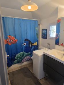 ein Badezimmer mit einem blauen Duschvorhang mit Fisch in der Unterkunft maison Disney family pour 14 personne a 5 mm de Disney in Magny-le-Hongre