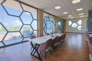 a conference room with a table and chairs and windows at Hotel Om Vilas in Jait