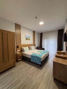 a hotel room with a bed and a desk at Hotel Panaya in Gokceada Town