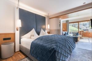 a bedroom with a large bed and a living room at Hotel Jerzner Hof 4 Sterne Superior in Jerzens