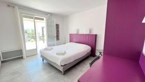 a bedroom with a bed with a purple wall at Villa avec piscine privée, à proximité de la plage et du centre de thalasso in Ars-en-Ré +8 photos