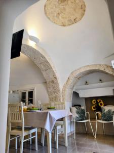 eine Küche und ein Esszimmer mit Tisch und Stühlen in der Unterkunft Trullo il Gelso with Private Salt Water Infinity Pool and Jacuzzi inside in San Michele Salentino