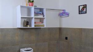 a bathroom with a toilet and a shelf with towels at Family Home by Havana Properties with WIFI & Free Parking near Sawa Sawa Bay Beach Restaurant in Dar es Salaam