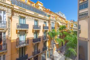 an apartment building with balconies and palm trees at Hypercentre - Spacieux trois pièces rénové - EG in Beausoleil