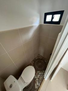 Un pequeño baño con inodoro y ventana. en Paypay Resthouse, en San Francisco