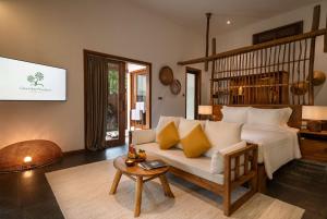 a living room with a white couch and a table at Green Bay Phu Quoc Resort & Spa in Phu Quoc