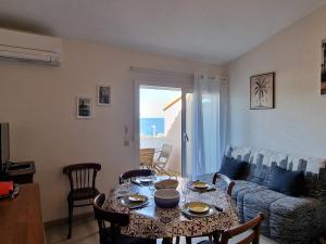 a living room with a table and a couch at Appartement T3 Climatisé avec Terrasse - Proche Crique, Parking Privé, Idéal Famille - FR-1-309-209 in Banyuls-sur-Mer