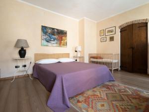 a bedroom with a purple bed and a rug at From the city to nature Mezzane di sotto VR pet-friendly in Postuman