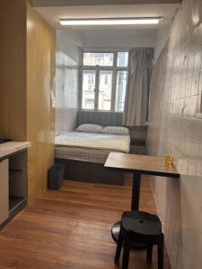 Camera piccola con letto, tavolo e finestra di 旅居1号 a Hong Kong