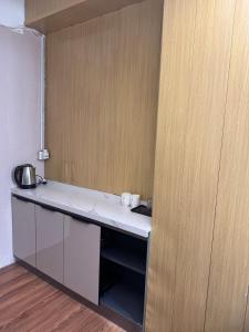 una cucina con un bancone bianco e una parete in legno di 旅居1号 a Hong Kong