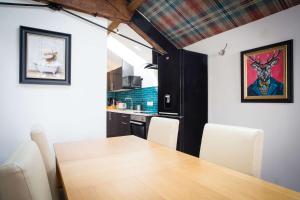 a kitchen and dining room with a wooden table and chairs at The Coach House by The Hive WA1 in Warrington +17 photos