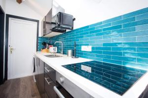a kitchen with blue tile on the wall at The Coach House by The Hive WA1 in Warrington