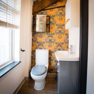 a bathroom with a toilet and a sink at The Coach House by The Hive WA1 in Warrington