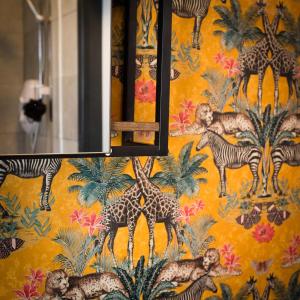 a wall with a colorful wallpaper with giraffes and zebras at The Coach House by The Hive WA1 in Warrington