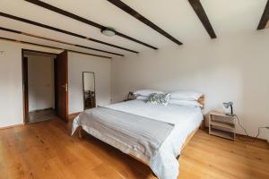 a bedroom with a bed and a wooden floor at Eco della Valle Apartments by Quokka 360 - with views of the surrounding mountains in Faido