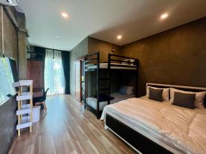a bedroom with a bunk bed and a desk at NADON VILLA in Ban Choko +8 photos
