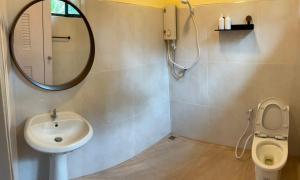 een badkamer met een wastafel en een spiegel en een toilet bij Uncle peiyk homestay in Ban Bang Bao