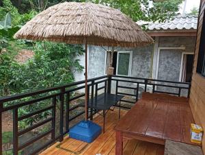 een patio met een tafel en een rieten parasol bij Uncle peiyk homestay in Ban Bang Bao +3 foto's