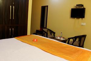 a bedroom with a bed and a table with chairs at Hotel O Prachi villa in New Delhi