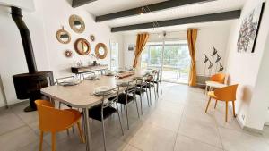 Un comedor con una mesa larga y sillas. en Superbe villa avec piscine chauffée, proche mer, en Ars-en-Ré
