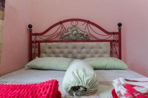 a bed with a red headboard and two pillows at LovKend in Ruteng
