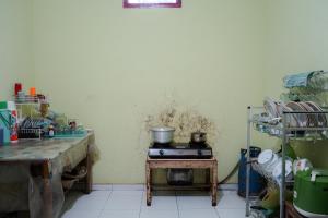 a kitchen with a stove and a table with pots and pans at LovKend in Ruteng