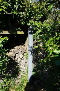 a white pole with graffiti on it in the grass at Villa Rétaise face mer - Sainte-Marie-de-Ré in Sainte-Marie-de-Ré