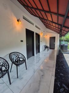 a patio with chairs and tables and a ceiling at Cabana banasura Wayanad 2bhk in Padinjarathara