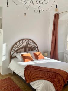 a bedroom with a bed with orange and white pillows at Appart centre historique Tulle in Tulle