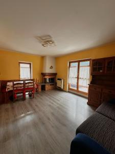 Una sala de estar vacía con paredes amarillas y pisos de madera. en Chalet Piazzi, en Semogo