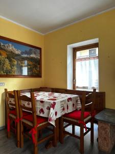 Un comedor con mesa y sillas y una ventana. en Chalet Piazzi, en Semogo