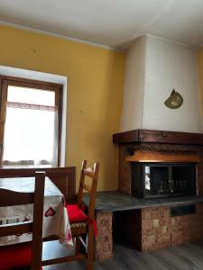 Una habitación con chimenea con una cama y una ventana. en Chalet Piazzi, en Semogo