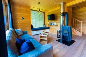 a living room with a blue couch and a stove at HOCHoben Chalets & Mobilhomes in Mallnitz
