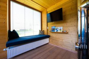 a room with a large window with a blue bench at HOCHoben Chalets & Mobilhomes in Mallnitz