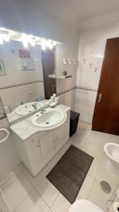 a bathroom with two sinks and a large mirror at CASA da LINHA in Deveza