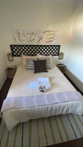 a large white bed with a bowl of flowers on it at CASA da LINHA in Deveza