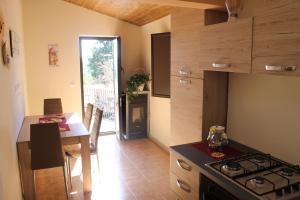 uma cozinha com um fogão e uma sala de jantar com uma mesa em Casa Vacanza Etna em Linguaglossa