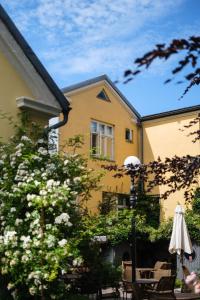 a yellow building with an umbrella in front of it at Köpmans Boutique Hotel & Bistro in Höganäs